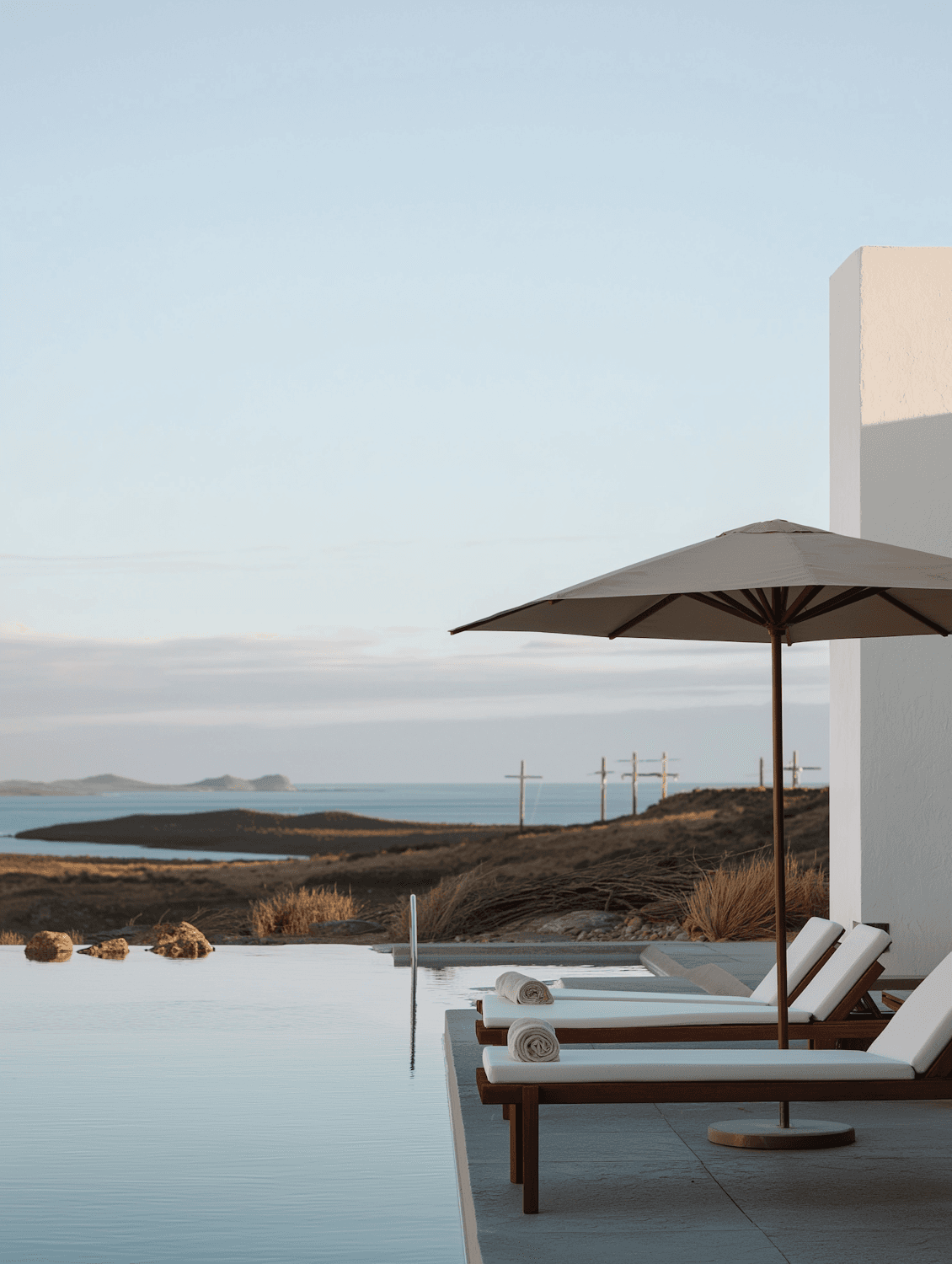 Wooden loungers beside an infinity pool overlooking the coast