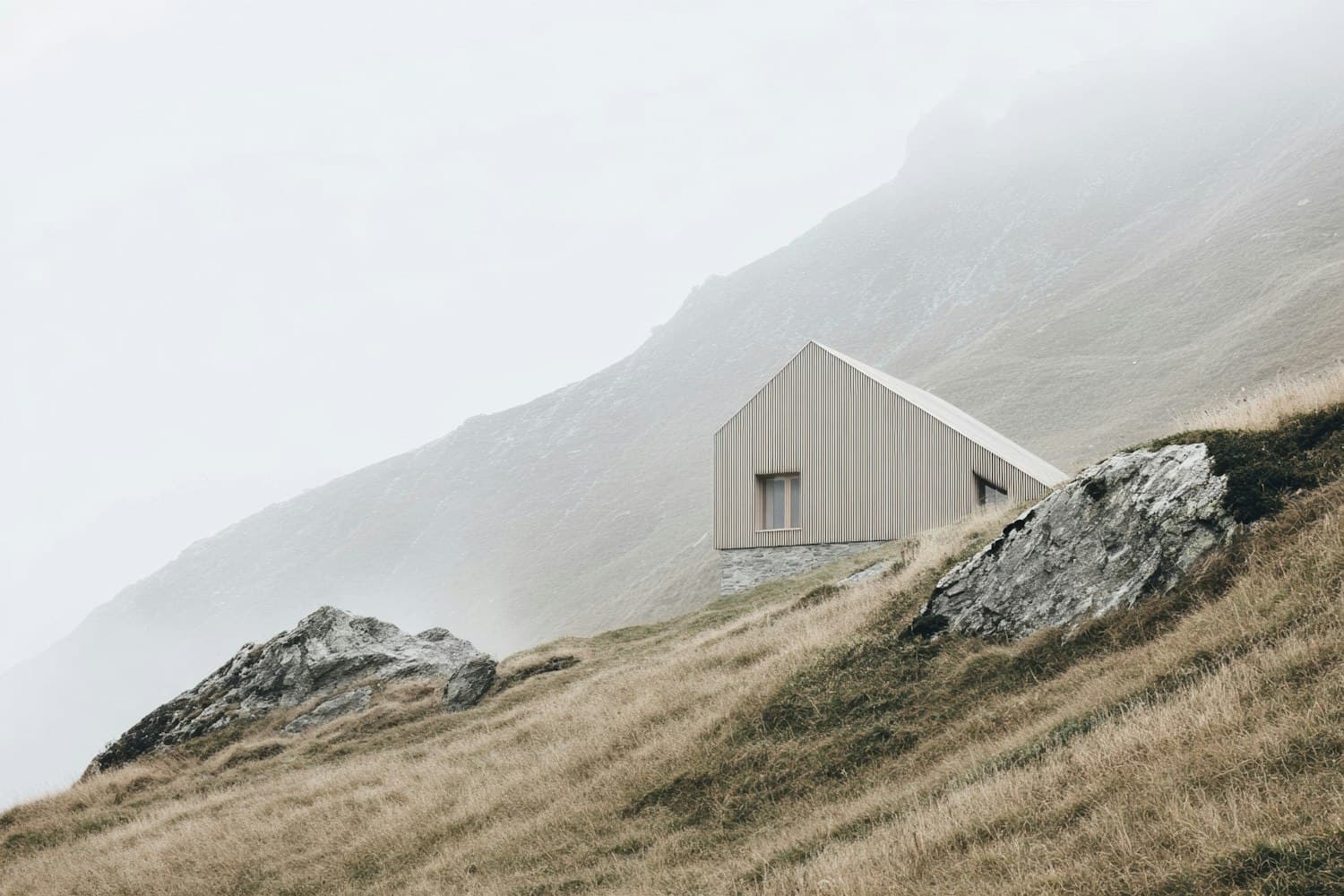 A small wooden cabin on a misty mountainside
