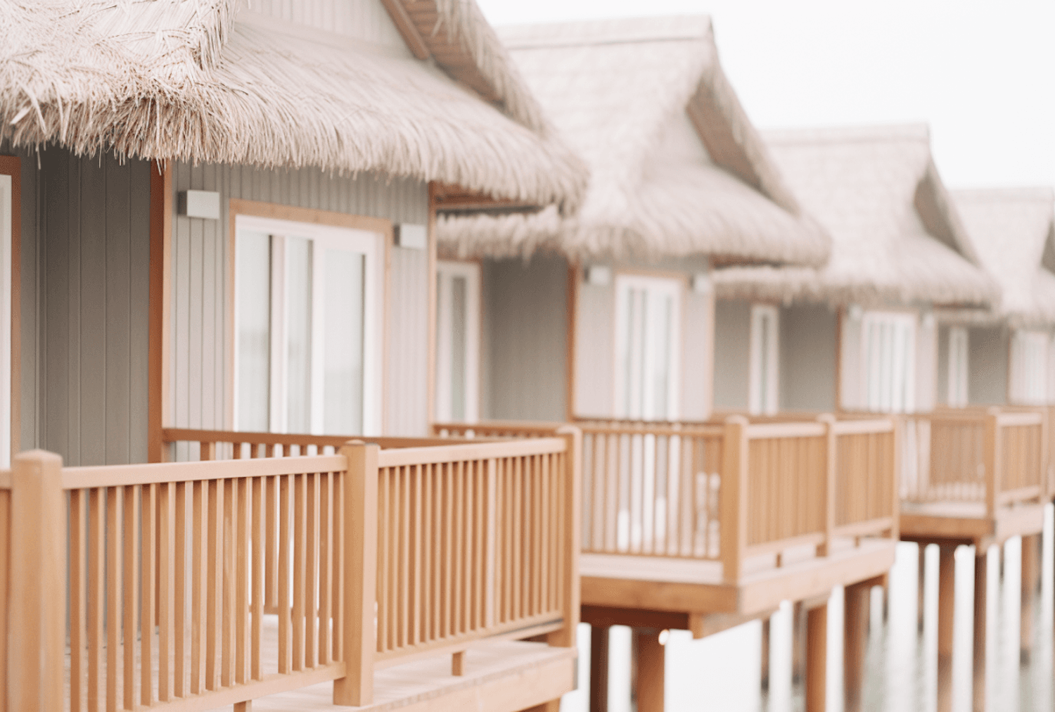 Thatched overwater villas with wooden decks above a calm lagoon