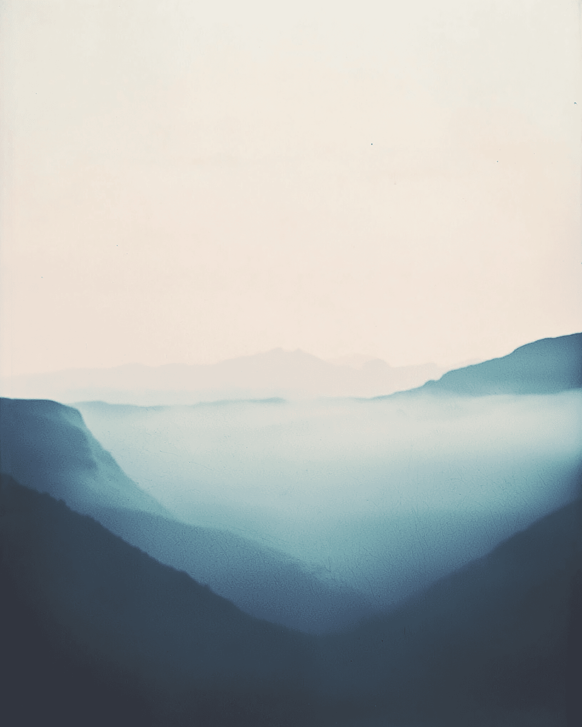 Layers of misty green hills fading into a pale sky